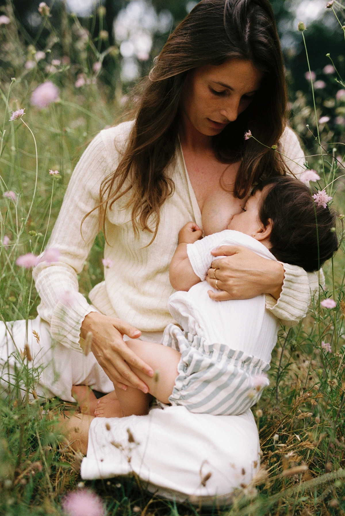 Madre dando el pecho a su hija durante una sesión de fotos de maternidad en el bosque de Sabadell